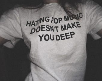 Camiseta con texto "Odiar la música pop no te hace profundo"