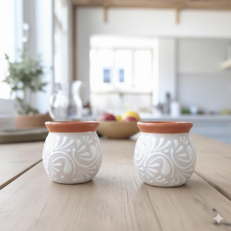 May include: A set of three ceramic mugs with a speckled, matte finish. The mugs are in shades of cream, light gray, and dark gray. Each mug has a simple, minimalist design, perfect for coffee or tea.