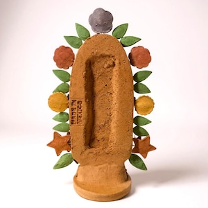 May include: A handcrafted terracotta sculpture with a central, elongated cavity. The sculpture is adorned with decorative elements including green leaves, orange stars, and flowers in shades of yellow, red, and gray. The text "MADE IN MEXICO" is visible on the side.
