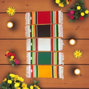 May include: A selection of vibrantly coloured woven table runners. The runners, in red, black, white, green, and yellow, have a central solid colour with striped borders and white fringe.