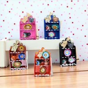 Può includere: Scaffali in miniatura in legno dipinti a mano in rosa, blu, marrone, rosso e nero. Ogni scaffale espone piccoli piatti, tazze e ciotole decorative. Gli scaffali hanno uno stile rustico e di arte popolare.