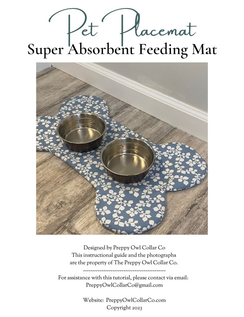 May include: A bone-shaped pet placemat featuring a blue fabric with a white leaf pattern. Two circular stainless steel bowls are placed on top of the mat. The text Pet Placemat Super Absorbent Feeding Mat is visible above the mat.