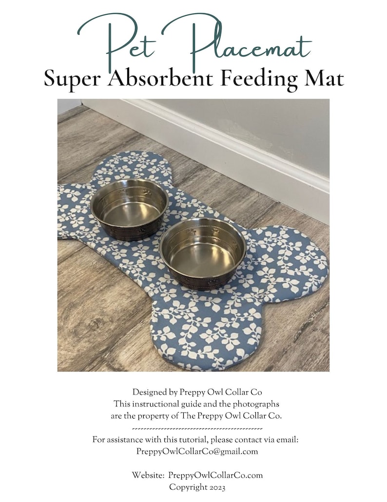 May include: A bone-shaped pet placemat featuring a blue fabric with a white leaf pattern. Two circular stainless steel bowls are placed on top of the mat. The text Pet Placemat Super Absorbent Feeding Mat is visible above the mat.
