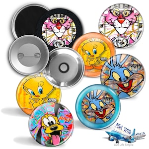 May include: A collection of colorful cartoon character button pins. The pins feature characters like the Pink Panther, Tweety Bird, Bugs Bunny, and Pluto. The pins have a glossy finish and are in various sizes.