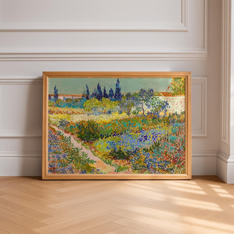 May include: A framed landscape painting with a wooden frame. The artwork depicts a colorful garden scene with a path, flowers, trees, and a wall. The painting's colors include blues, greens, yellows, and reds.