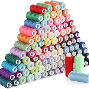 Peut inclure: Un ensemble de bobines de fil colorées dans diverses teintes, notamment le rouge, le vert, le bleu, le rose et le jaune. Les bobines sont empilées, créant une présentation vibrante de fournitures de couture.