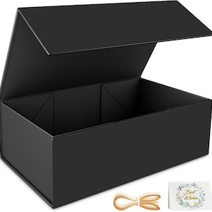 May include: A black gift box with a magnetic closure, partially open, showing an empty interior. A light brown ribbon and a card with the words "Best Wishes" are next to the box. The box is designed for presenting gifts.