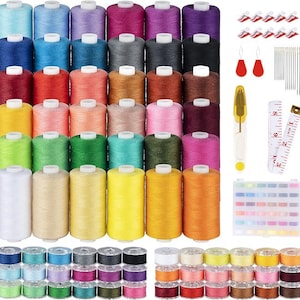 Puede incluir: Un kit de costura con una variedad de carretes de hilo de colores, bobinas, agujas y una cinta métrica. Los colores del hilo incluyen azul, rosa, verde, amarillo y naranja. También se incluyen pinzas de costura y un enhebrador.