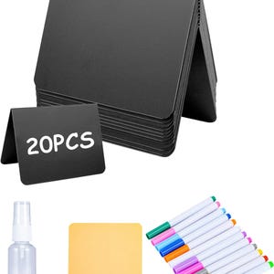 Puede incluir: Un conjunto de letreros de mesa negros y plegables con el texto "20PCS" en blanco. También se incluyen un pulverizador transparente, un paño de limpieza amarillo y un juego de rotuladores de colores.
