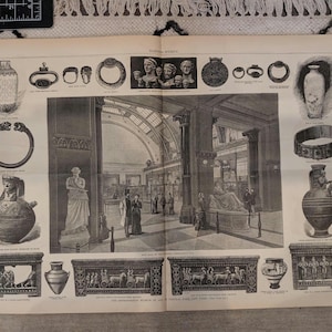 以下が含まれることがあります： 花瓶、宝石、彫刻など、さまざまな古代の遺物を白黒で描いたイラスト。この画像は、人々や古典的な建築物のある博物館の内部を詳細に描写しています。遺物はテキストが書かれたページに表示されています。
