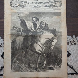 May include: An antique Harper's Weekly Journal of Civilization newspaper dated June 9, 1860. The black and white print features an illustration of General Giuseppe Garibaldi on horseback, pointing forward with a sword, surrounded by soldiers.
