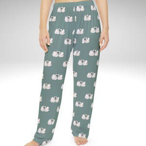 Puede incluir: Pantalones de pijama verde salvia con un patr&oacute;n repetido de cisnes blancos y rosas. Los pantalones tienen un corte relajado y una cintura c&oacute;moda. El dise&ntilde;o de cisnes a&ntilde;ade un toque de elegancia a la ropa de dormir.