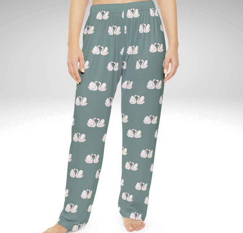 Puede incluir: Pantalones de pijama verde salvia con un patr&oacute;n repetido de cisnes blancos y rosas. Los pantalones tienen un corte relajado y una cintura c&oacute;moda. El dise&ntilde;o de cisnes a&ntilde;ade un toque de elegancia a la ropa de dormir.