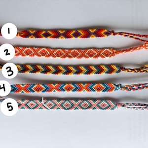May include: Five woven friendship bracelets arranged horizontally, each featuring distinct geometric patterns and vibrant color combinations. Numbered white circles from 1 to 5 are placed over the left side of each bracelet, which include braided ties.