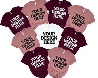 May include: A collection of t-shirts in various colors, including white, burgundy, and mauve. Each shirt features the text "YOUR DESIGN HERE" in a bold, black font. The shirts are arranged in a circular pattern.