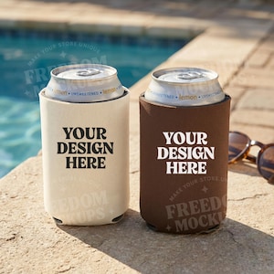 May include: Two beverage can coolers, one beige and one brown, each with the text "YOUR DESIGN HERE" in bold white letters. The beige cooler has the text "FREEDOM MOCKUPS" at the bottom. The brown cooler has the text "FREED MOCKU" at the bottom.