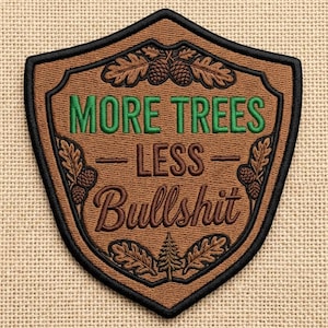 May include: Embroidered patch in a shield shape with the text "MORE TREES - LESS Bullshit" in green and brown. The patch has a brown background with black trim and decorative oak leaves and pinecones.