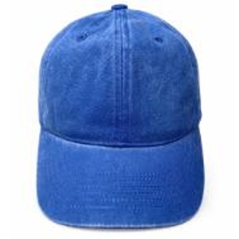 Puede incluir: Una gorra de b&eacute;isbol de color azul real s&oacute;lido con una construcci&oacute;n de seis paneles, una visera curva y un bot&oacute;n cubierto de tela en la parte superior. La gorra presenta una textura desgastada y lavada en toda la tela, d&aacute;ndole un aspecto usado.