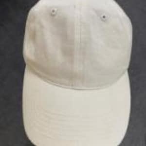 Puede incluir: Una gorra de b&eacute;isbol de color blanco roto liso con una corona estructurada de seis paneles, ojales bordados a juego y una visera curva. La gorra est&aacute; confeccionada en tela lisa e incluye una costura vertical central en el panel frontal.