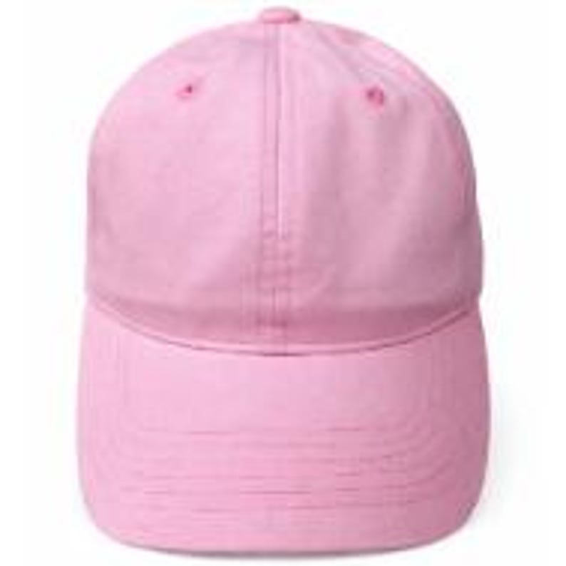 Puede incluir: Una gorra de b&eacute;isbol de color rosa claro liso con una construcci&oacute;n de seis paneles, visera curva, un bot&oacute;n en la parte superior central y ojales cosidos en cada panel. La gorra cuenta con una corona frontal estructurada y una tira.