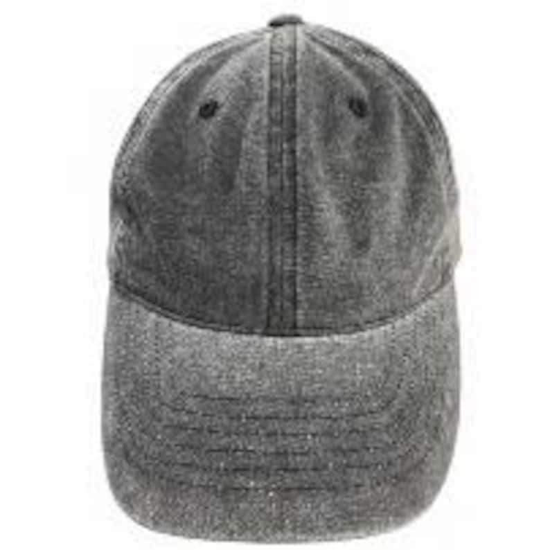 Puede incluir: Una gorra de b&eacute;isbol gris carb&oacute;n con un acabado de tela desgastada y lavada. La gorra presenta una construcci&oacute;n de seis paneles con visera curva, costuras reforzadas a lo largo de los paneles y peque&ntilde;os ojales de ventilaci&oacute;n en la corona.