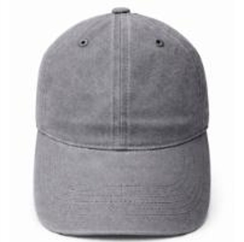 Puede incluir: Una gorra de b&eacute;isbol de color gris s&oacute;lido con una construcci&oacute;n de seis paneles, visera curva y un bot&oacute;n en la parte superior. La tela tiene una textura ligeramente desgastada y lavada, con ojales cosidos en la corona para ventilaci&oacute;n.