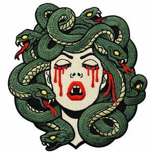 May include: Embroidered patch featuring Medusa with snakes for hair. The design includes a pale face with closed eyes, red tears, and a red open mouth with fangs. The snakes are green with yellow eyes and red tongues.