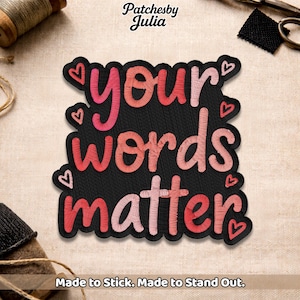 May include: Embroidered patch with the phrase "your words matter" in pink and red lettering on a black background. Small heart accents are scattered around the text. The patch is designed to be ironed on or sewn.