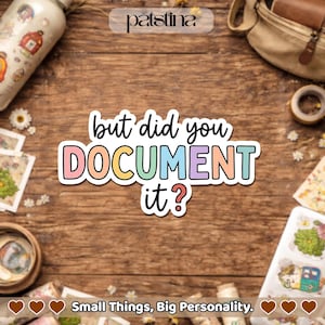 May include: A colorful sticker with the text "but did you DOCUMENT it?" in a playful font. The sticker has a white border and pastel colors. The image also includes a water bottle, a bag, and other stationery items on a wooden surface.