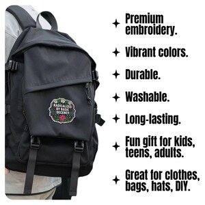 May include: Black backpack with a patch that reads "RADICALIZED BY BASIC DECENCY" surrounded by a floral design. The image also includes text that says "Premium embroidery", "Vibrant colours", "Durable", "Washable", "Long-lasting", "Fun gift for kids, teens, adults", and "Great for clothes, bags, hats, DIY."