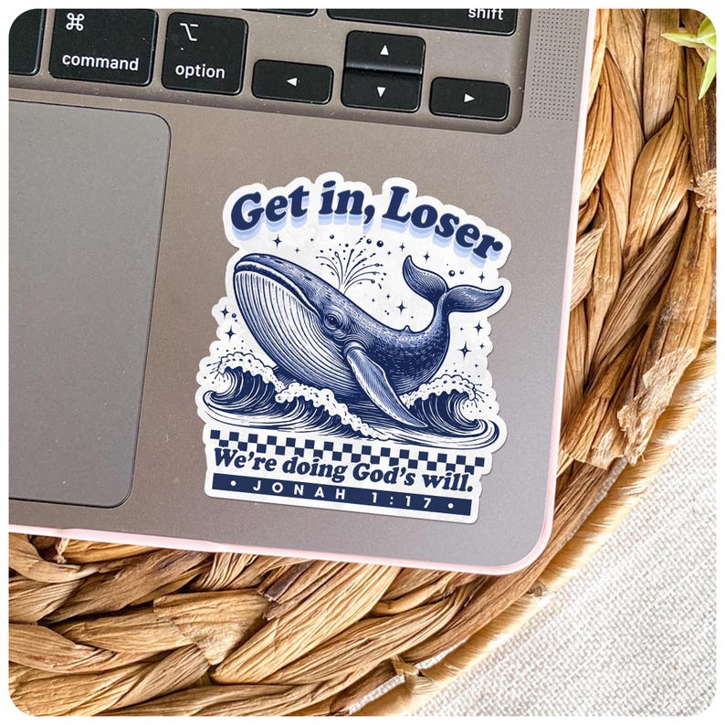 May include: A navy blue sticker featuring a whale illustration with the text "Get in, Loser" above and "We're doing God's will. Jonah 1:17" below. The sticker is placed on a laptop.