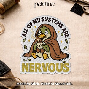 May include: Embroidered patch featuring a cartoon duck in a brown cloak, holding a cup of coffee. The patch reads "ALL OF MY SYSTEMS ARE NERVOUS" in a circular design. The patch is white with yellow and green accents. The text "Made to Stick. Made to Stand Out." is at the bottom.