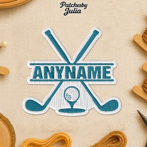 May include: Embroidered patch featuring crossed golf clubs, a golf ball on a tee, and the text "ANYNAME" in teal and white. The patch has a white border and is set against a beige fabric background.