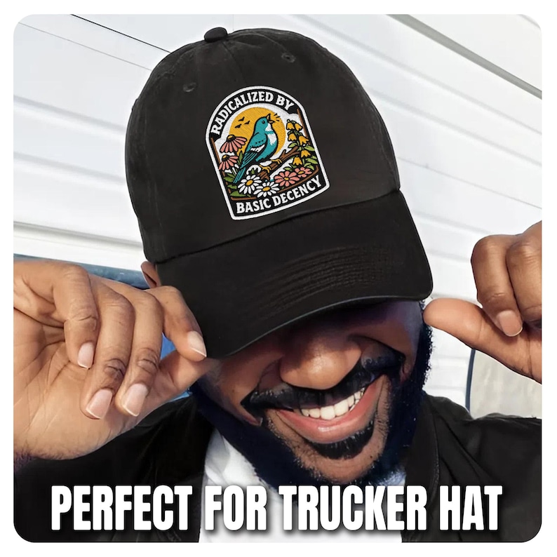 May include: Black baseball cap with a patch featuring a blue bird, flowers, and the text "RADICALIZED BY BASIC DECENCY." The cap is a classic style, suitable for casual wear.