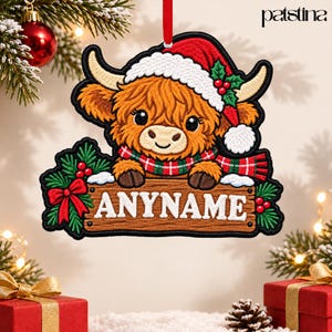 May include: A hanging ornament featuring an embroidered Highland cow wearing a red and white Santa hat and a red and green plaid scarf. The cow holds a wooden sign with the text ANYNAME, decorated with green holly leaves and red berries.