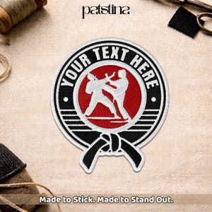 May include: Embroidered patch with a martial arts theme. The patch features a red circle with two white figures in a fighting stance, surrounded by a black and white border. The text "YOUR TEXT HERE" is arched around the circle.