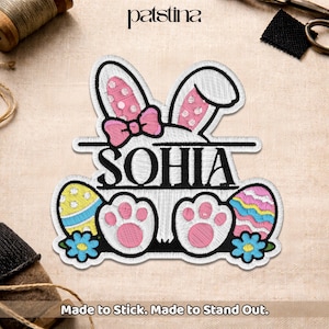 May include: Embroidered Easter-themed patch featuring a bunny with pink polka-dot ears and a bow, the name "SOHIA", and Easter eggs. The patch includes the text "Made to Stick. Made to Stand Out."