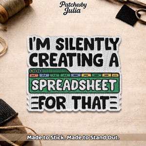 May include: Embroidered patch with the text "I'M SILENTLY CREATING A SPREADSHEET FOR THAT" in black, white, green, blue, and yellow. The patch has a white border and is on a beige fabric background. The brand name "Patchesby Julia" is at the top.