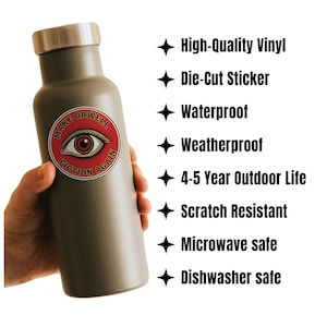 May include: A gray insulated water bottle with a silver lid, held by a hand. A round sticker on the bottle reads "MAKE ORWELL FICTION AGAIN" with an eye graphic. Features include high-quality vinyl, die-cut, waterproof, weatherproof, and scratch-resistant.