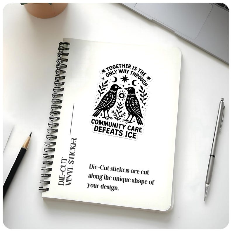 May include: A die-cut vinyl sticker on a spiral notebook. The sticker features two black birds facing each other, with the text "TOGETHER IS THE ONLY WAY THROUGH" and "COMMUNITY CARE DEFEATS ICE". Additional text states, "Die-Cut stickers are cut along the unique shape of your design."