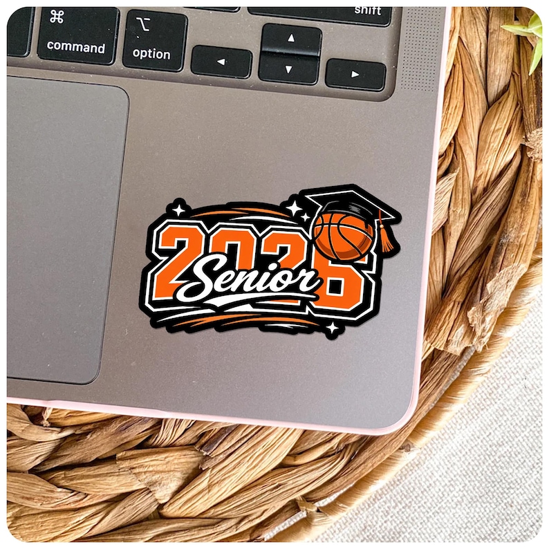 Pu&ograve; includere: Un adesivo con la scritta "2023 Senior" in arancione e bianco, con un pallone da basket con un cappello di laurea. L'adesivo &egrave; su un laptop, con uno sfondo intrecciato.