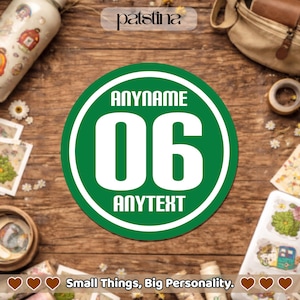 May include: A green and white circular sticker with the text "ANYNAME", the number "06", and the text "ANYTEXT". The sticker is on a wooden surface, surrounded by craft supplies and the text "Small Things, Big Personality."