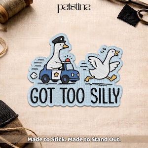 May include: Embroidered patch featuring a goose in a police car and another running away. The patch is light blue with the words "GOT TOO SILLY" in black. The patch also has the text "Made to Stick. Made to Stand Out."