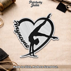 May include: Embroidered patch featuring a black gymnast in a handstand pose within a white heart shape. The patch includes the name "Aryanne" in script and the text "Made to Stick. Made to Stand Out."