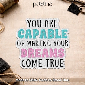 May include: Embroidered patch with the words "YOU ARE CAPABLE OF MAKING YOUR DREAMS COME TRUE" in black, teal, and pink. The patch has a white border and the text "Made to Stick. Made to Stand Out."