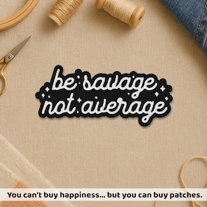 May include: Black embroidered patch with the words "be savage not average" in white script. The patch is surrounded by small white star-like accents. The image also includes sewing supplies and the text "You can't buy happiness... but you can buy patches."