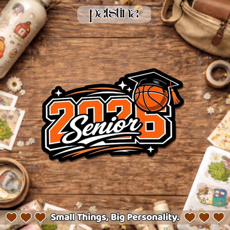 Pu&ograve; includere: Un adesivo arancione, nero e bianco con la scritta "2023 Senior" e un pallone da basket con un cappello di laurea. L'adesivo ha un contorno nero ed &egrave; su una superficie di legno. Il testo "Small Things, Big Personality" &egrave; in basso.