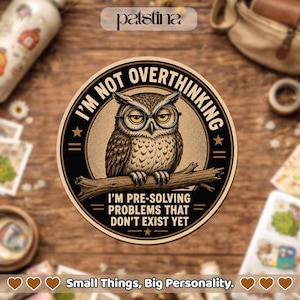 May include: A circular sticker featuring a brown owl wearing round glasses perched on a branch. The text reads I'M NOT OVERTHINKING and I'M PRE-SOLVING PROBLEMS THAT DON'T EXIST YET. The design uses a black and tan color palette with stars.