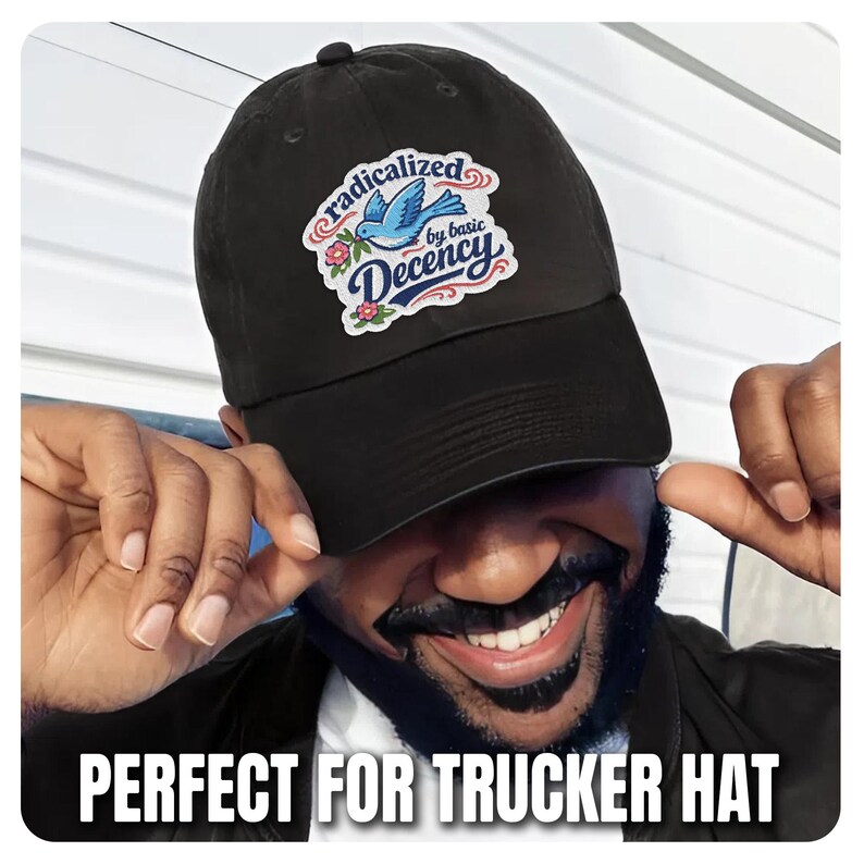 K&ouml;nnte beinhalten: Schwarze Baseballkappe mit einem Aufn&auml;her mit einem blauen Vogel, Blumen und den Worten "radicalized by basic Decency". Der Text "PERFECT FOR TRUCKER HAT" befindet sich am unteren Rand des Bildes.