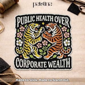 May include: Embroidered patch with the text "PUBLIC HEALTH OVER CORPORATE WEALTH". The patch features two tigers, one yellow and one orange, surrounded by flowers. The patch is black with white stitching and the text "Made to Stick. Made to Stand Out."